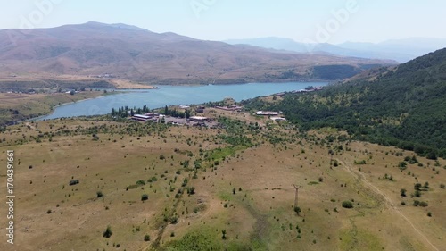 Aerial video of a mountain lake with yellow grasslands around it in Armenia.