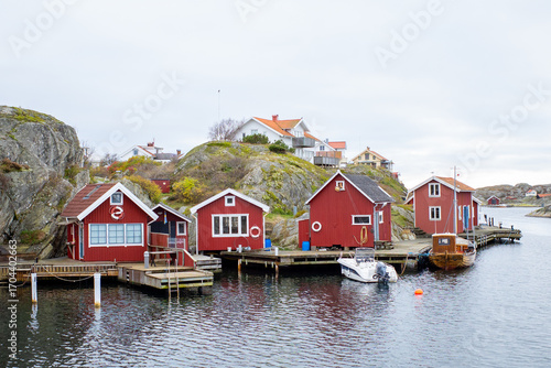A typical Scandinavian coastal landscape with traditional red wooden cabins, boats and fishing huts, perfect for travel, architecture