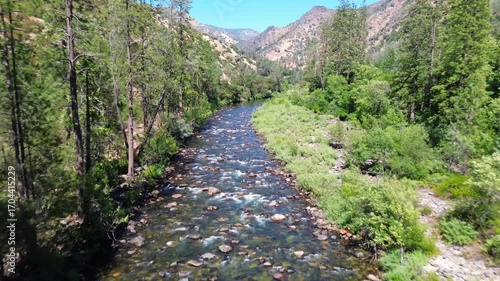 Aerial video of a river in a green valley near Yosemite National Park.