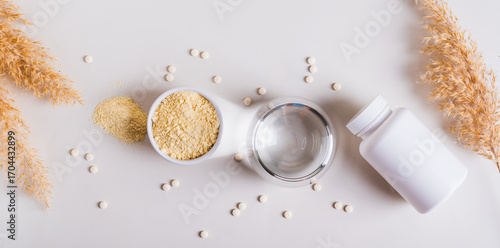Health food with peptides and water in a glass on the table top view web banner