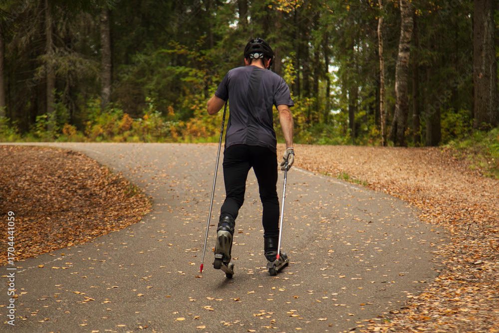 Fototapeta premium A man roller-skating in an autumn park. Cross-country.