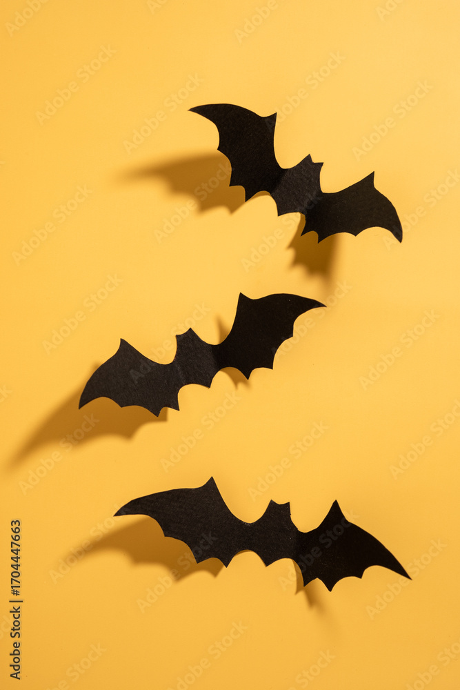 Naklejka premium Three black bats are hanging from the ceiling