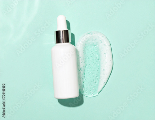 White Dropper Bottle with Silver Accent and Gel Swatch on Mint Background