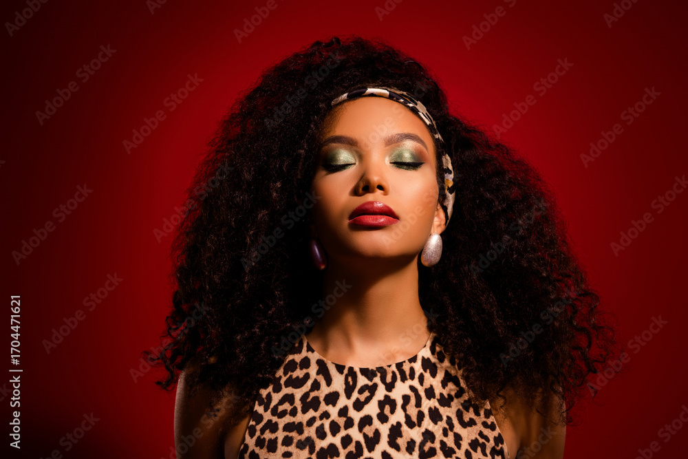 Fototapeta premium Stunning young woman posing with glamorous makeup, leopard print outfit, and bold curly hair