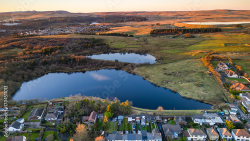 Fotografía Aerial view of Ebbw Vale town and reservoirs during golden hour in winter