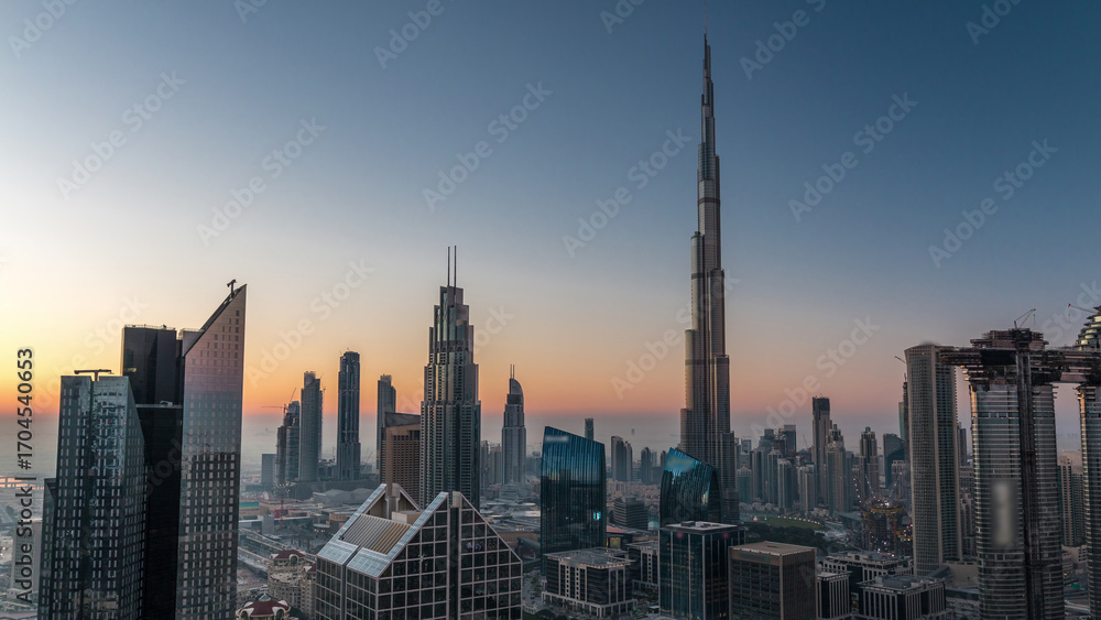 Naklejka premium Dubai downtown skyline with tallest skyscrapers and busiest traffic on highway intersection night to day timelapse