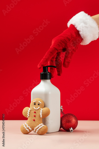 Santa Claus's hand takes a mock up of a cosmetic skin care product on a New Year's background 