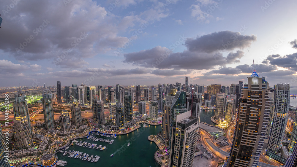 Obraz premium Dubai Marina skyscrapers and jumeirah lake towers view from the top aerial day to night timelapse in the United Arab Emirates.