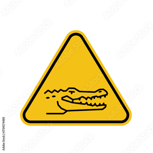 Alligator warning sign alerts visitors to potential danger near riverbank, emphasizing caution and awareness of wildlife in natural habitat.