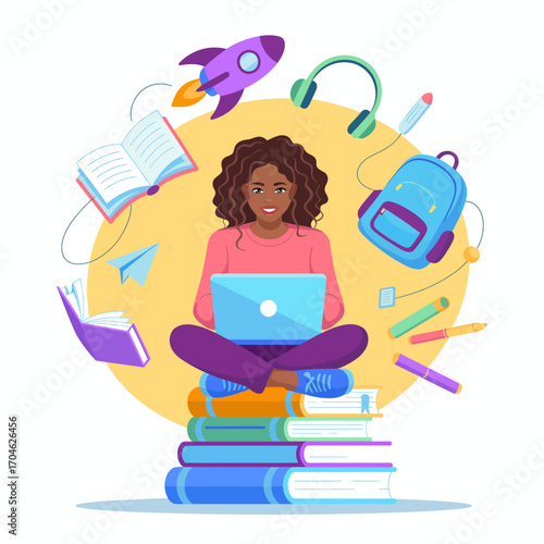 A cheerful young girl sits cross-legged on stacks of books, using a laptop with various educational items surrounding her, embodying the essence of online learning.