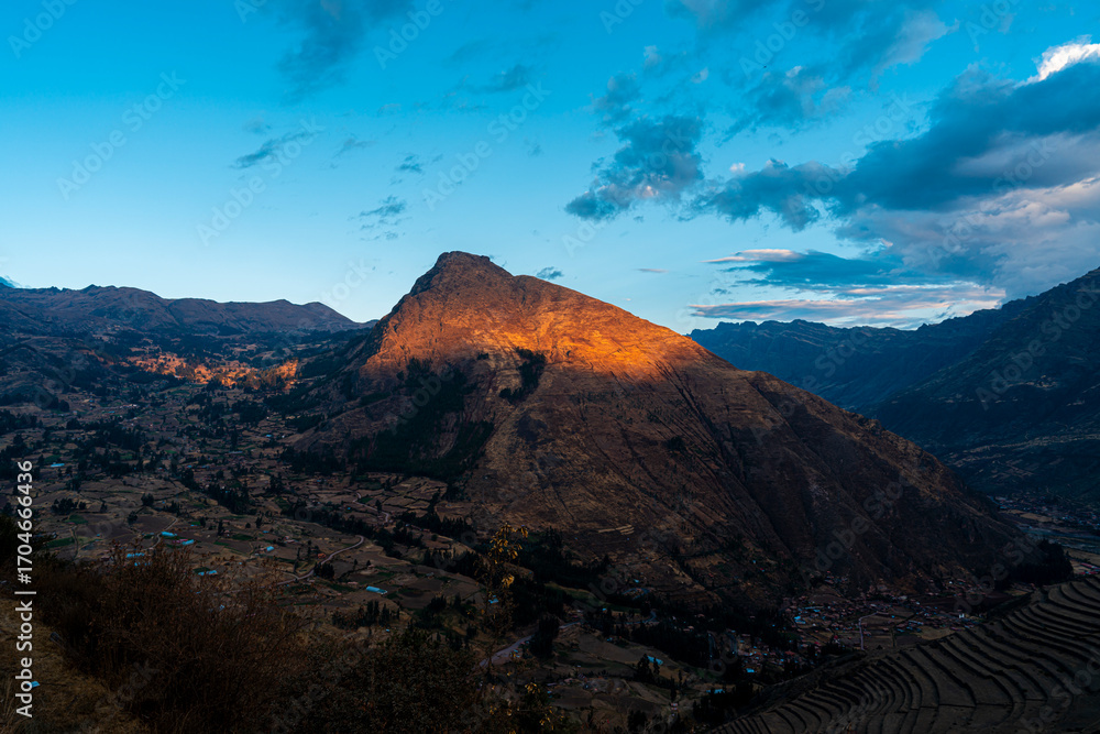 Obraz premium Golden sunset over the Sacred Valley in Cusco, Peru, with light on the mountain peak, terraces, and dramatic Andean landscapes.