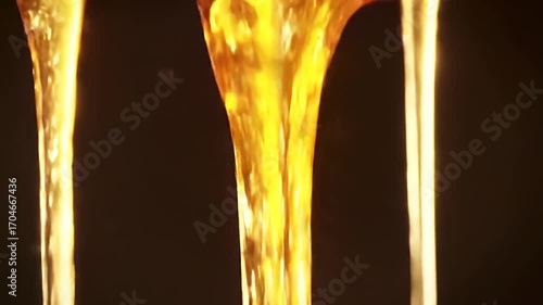 Golden Syrup Cascade: Mesmerizing Liquid Amber Flowing in a Viscous Stream on Black backdrop