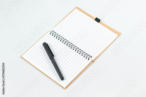 Wallpaper Mural a blanked notebook with a white lined sheets and a black pen over the left sheet and a white background Torontodigital.ca