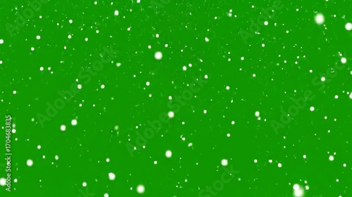 Snowfall effect with bright white snowflakes falling against a green screen backdrop