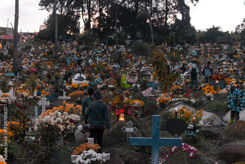 Photograph of children walking through a cemetery with flowers and clerestory on a cloudy day