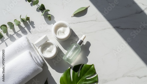 Elegant Skincare Flatlay with Cream, Towel, and Greenery on a Marble Surface for an Upscale Aesthetic in Natural Lighting