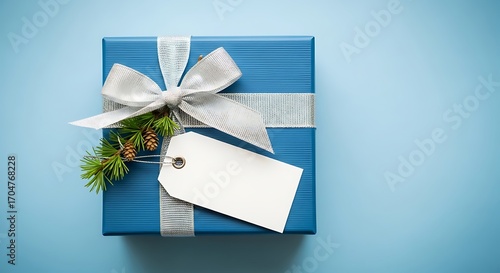 Blue Gift Box with White Ribbon and Tag on Blue Background.