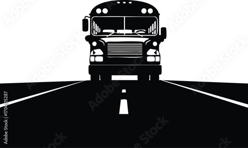 Front view of a black and white school bus driving on an asphalt road the bus is in silhouette, and the road is leading directly to the viewer