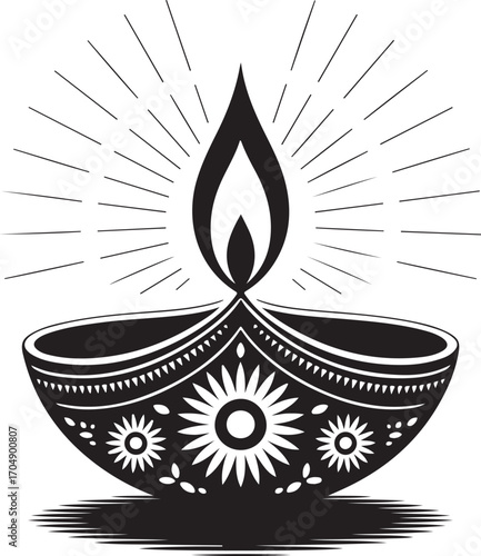This is a black and white illustration of a decorative oil lamp, known as a diya. The lamp has an ornate, floral design on its body and a prominent flame emanating upward,surrounded by radiating light