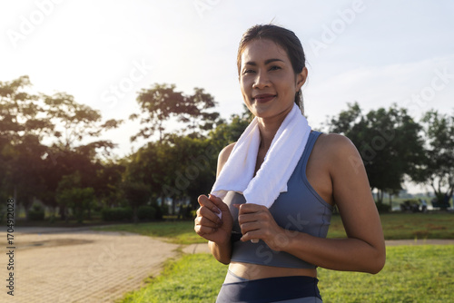 Obraz na plátně Asian woman middle-aged in sportive wear for morning jogging or sportive walk stroll in park smile look at camera