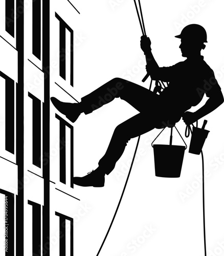 Silhouette of a window cleaner rappelling down the side of a modern building
