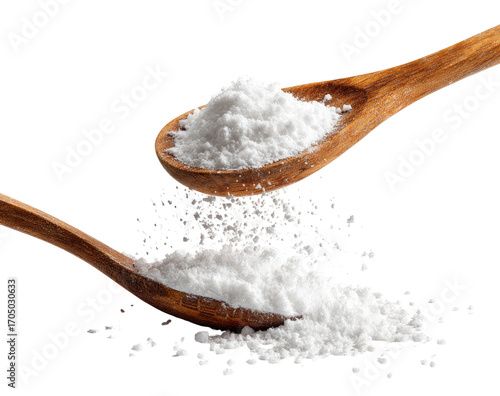 Two wooden spoons overflowing with white powder, some scattering