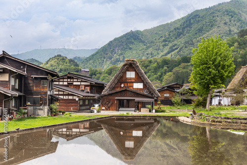 Scenic Shirakawa traditional village in Gifu Prefecture, Central Japan wtih gassho zukuri building style next to pond during springtime