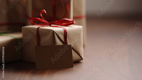 Slide shot of brown paper gift box with red bow on wood table
