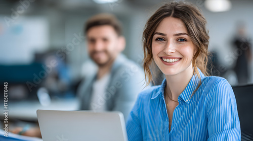 Happy Woman Accountant at Work in Office Environment with Laptop and Colleagues in Background