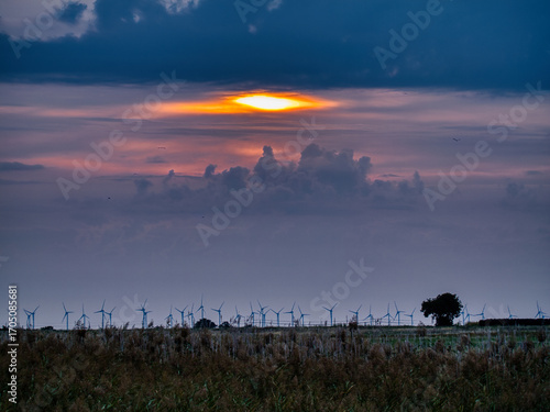 Stunning sunset sky with dramatic cloud formations glowing in shades of orange, purple, and blue. Atmospheric light rays create a magical evening mood, perfect for nature, travel, and scenic backgroun
