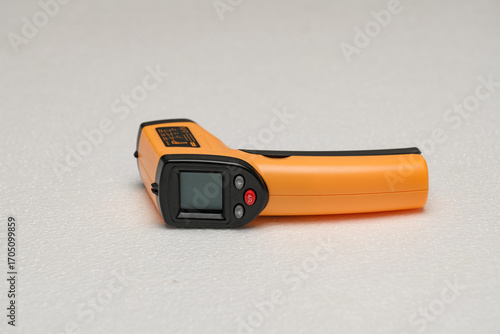 Handheld infrared thermometer in orange