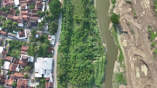Aerial View Showing a Small Rural Settlement Adjacent to a Dense Tropical Forest and a Water Canal Flowing Through Dry