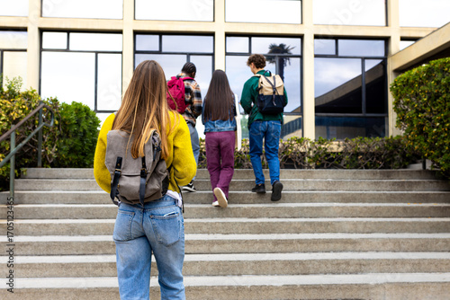Students walking up stairs at school building entrance