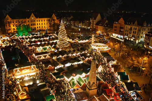 Traditional Christmas market in Erfurt, Thuringia in Germany. With xmas tree, pyramide and sales and food stands on late evening or night.