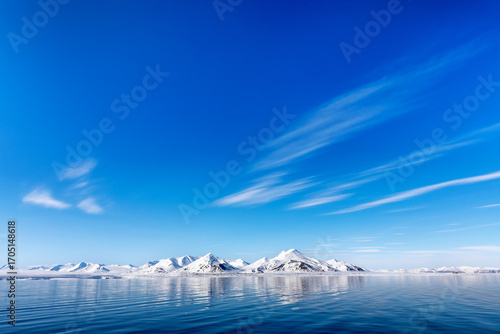 Tableau sur toile The blue arctic ocean, pristine snow covered mountains and summer sky