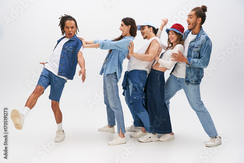 Carta da parati Young stylish friends showcase their playful fashion on a bright studio backdrop