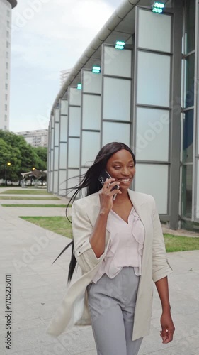 Young smiling African american businesswoman talking on phone outdoors