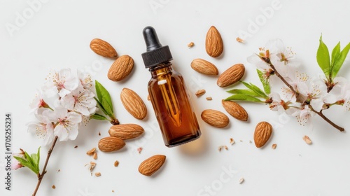 Almond Oil Bottle with Nuts and Blossoms on White Background