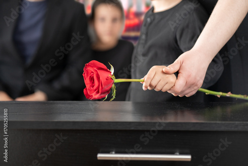 Fotografie A son with his mother at a funeral with respect, grief, or loss at the family burial service