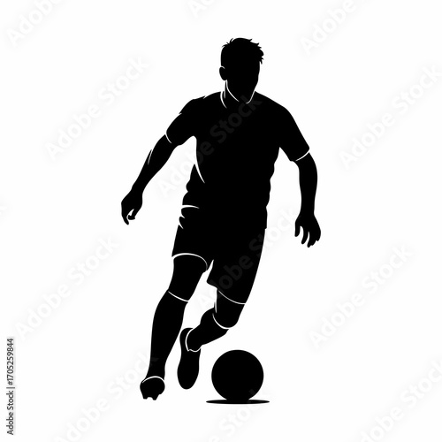 The silhouette of a soccer player dribbling the ball