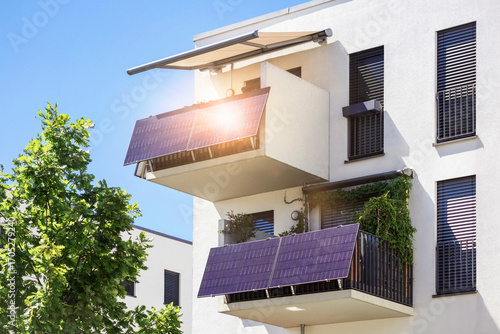 Solar Panels on Modern Balcony Apartment Building with Balcony Canopy and Sunlight Reflection.