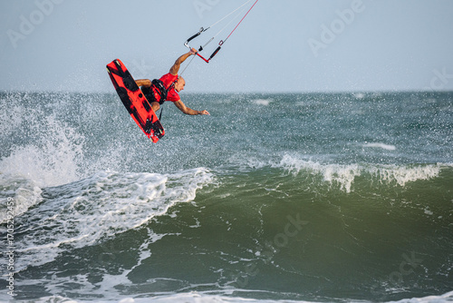 extreme kitesurfer riding a kite on the waves in the sea