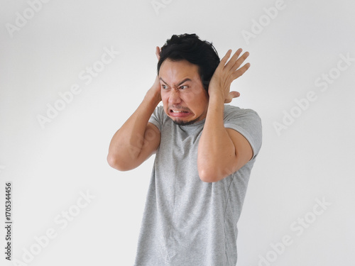 Man with a beard and a gray shirt is making a funny face and yelling