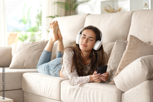 Woman relaxing listening streaming audio from headphone
