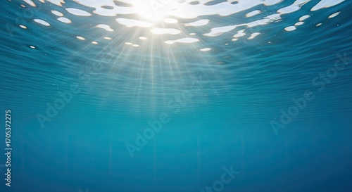 Sunlight filtering through clear blue ocean water from below the surface.