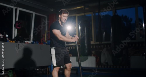 In a dim boxing ring, a determined man showcases his skills in an intense match