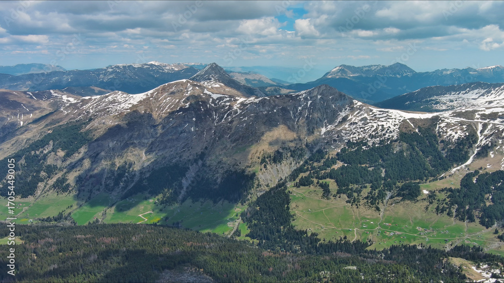 Fototapeta premium Rocky mountains in snow and green fir forest