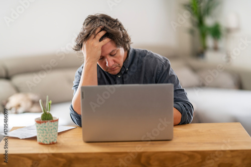 Frustrated Man Facing Laptop in a Domestic Setting
