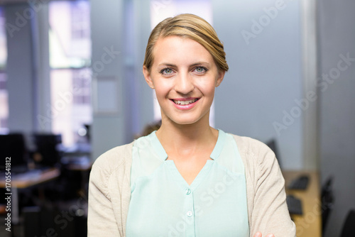 Free Download Female office professional standing and smiling at modern office with desks monitors and keyboard - GFXLoad