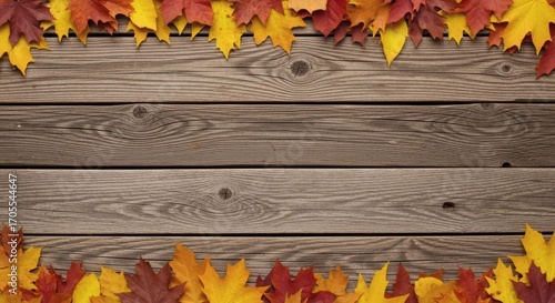 An autumn season background with a rustic wooden table and colorful maple leaves arranged to create a beautiful, festive frame and border